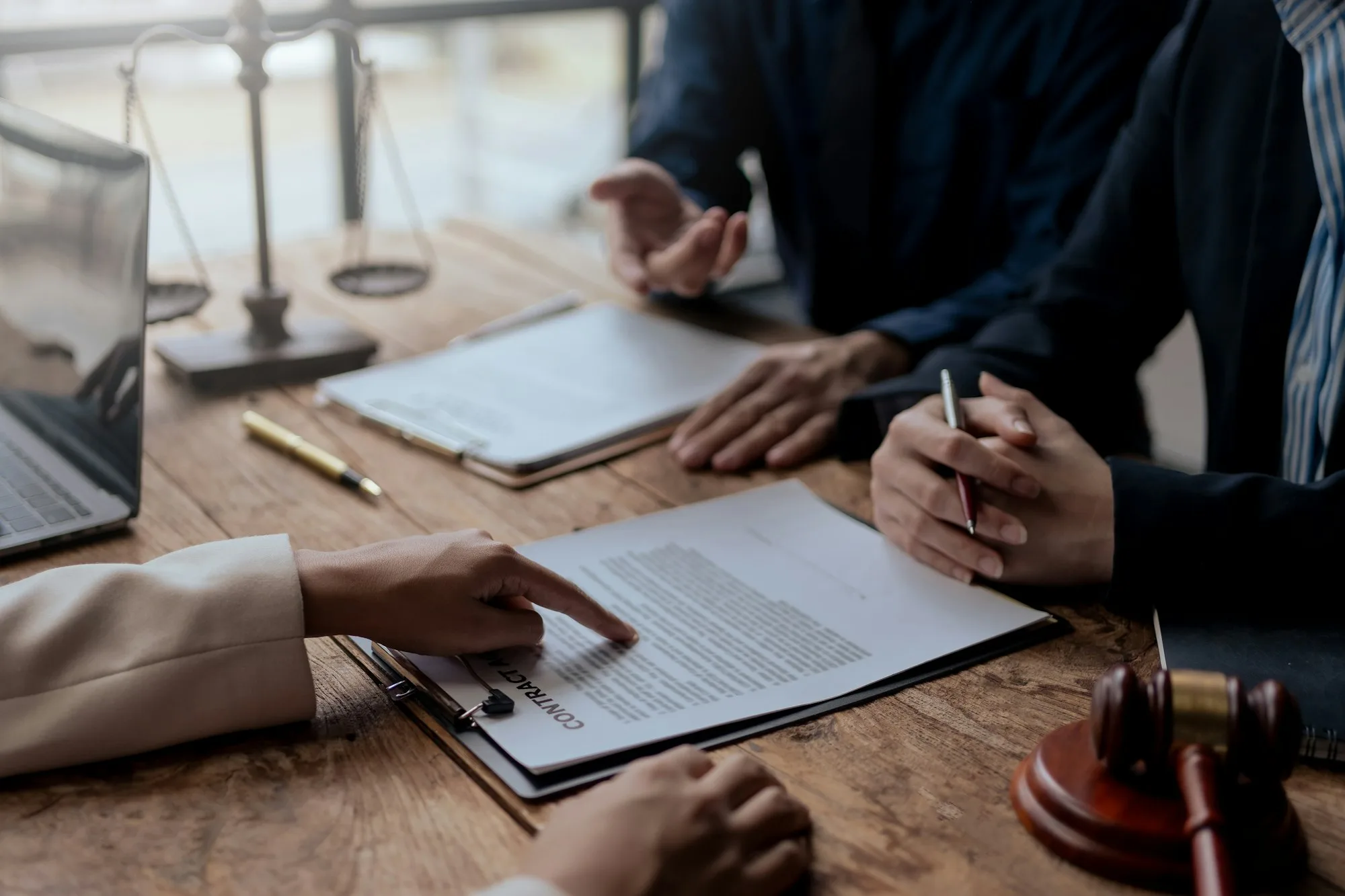 Abogados discutiendo documentos de contrato en una reunión de renegociación de deudas