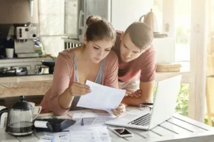 Pareja joven gestionando sus finanzas y revisando sus cuentas bancarias